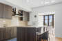 Cocina con isla central y mesa junto a ventana